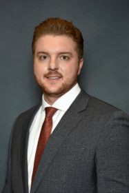 A man in a suit with a mustache.